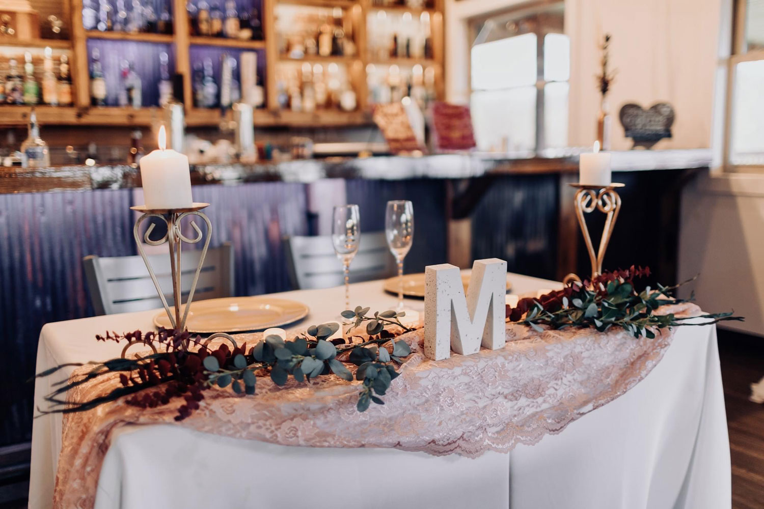 Sweetheart table with flowers and candles.