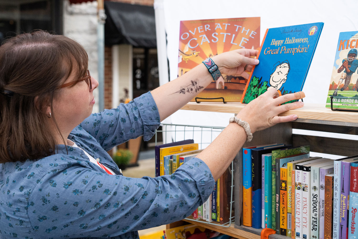 Caitie Cox arranging books on shelf