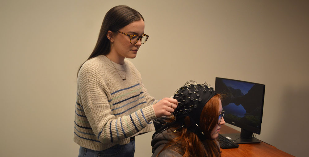 Desiree Johnson prepares an EEG cap to measure the brain’s electrical activity.