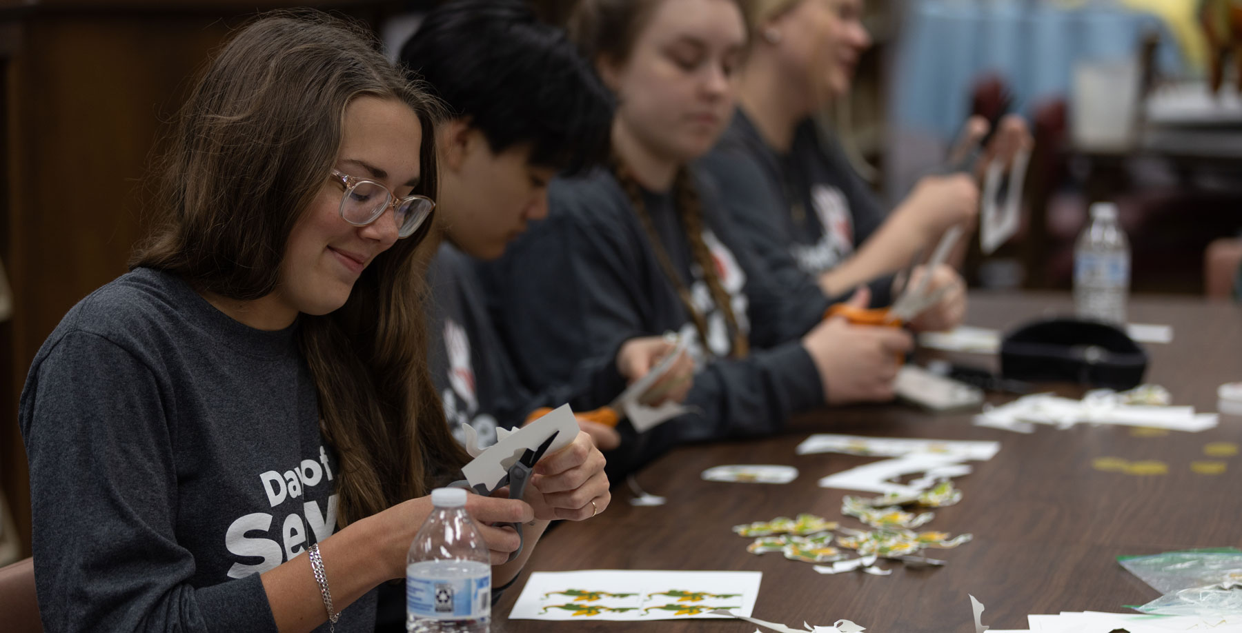 Students at table cutting with scissors