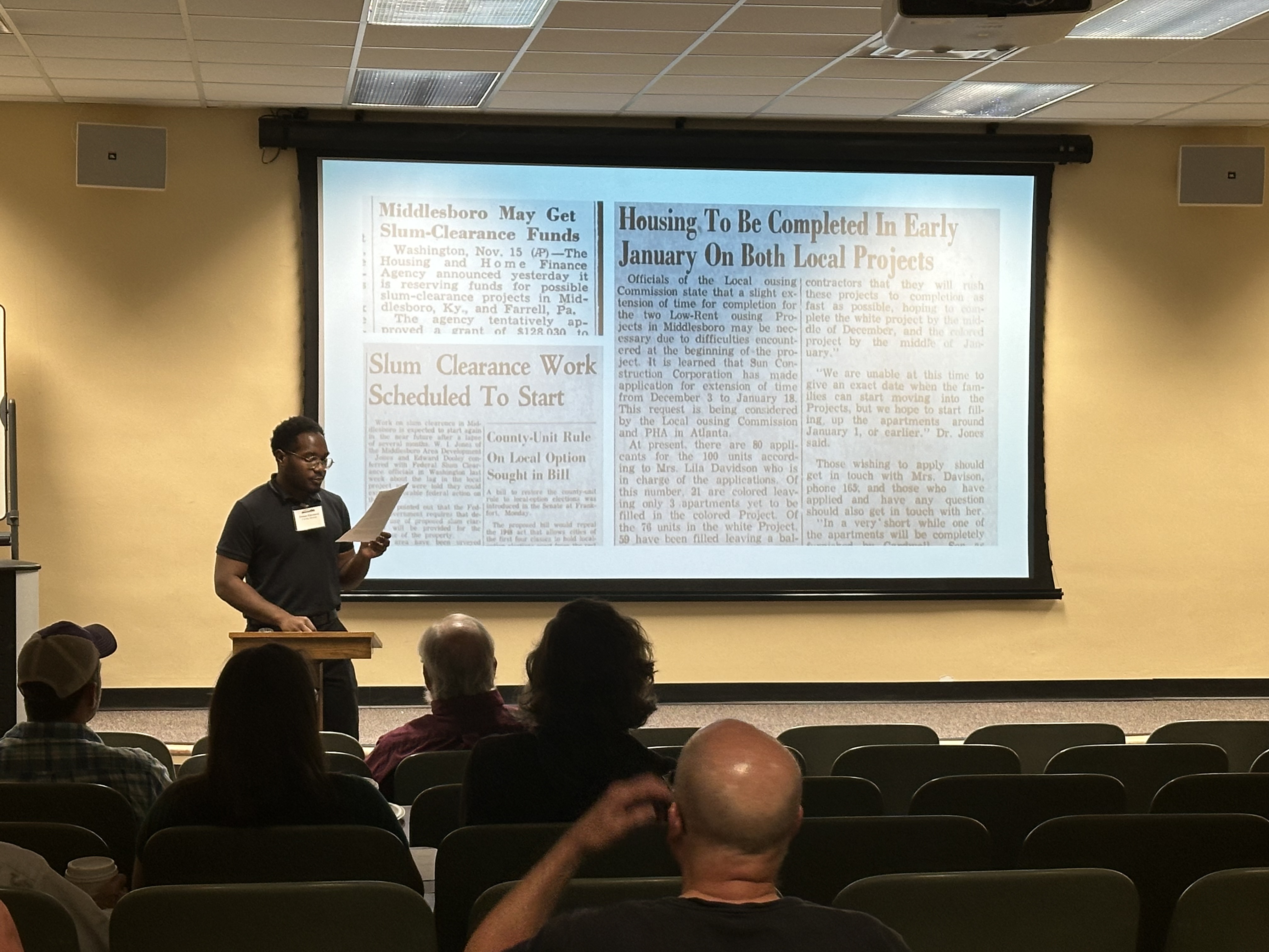 Presenter at podium in front of screen