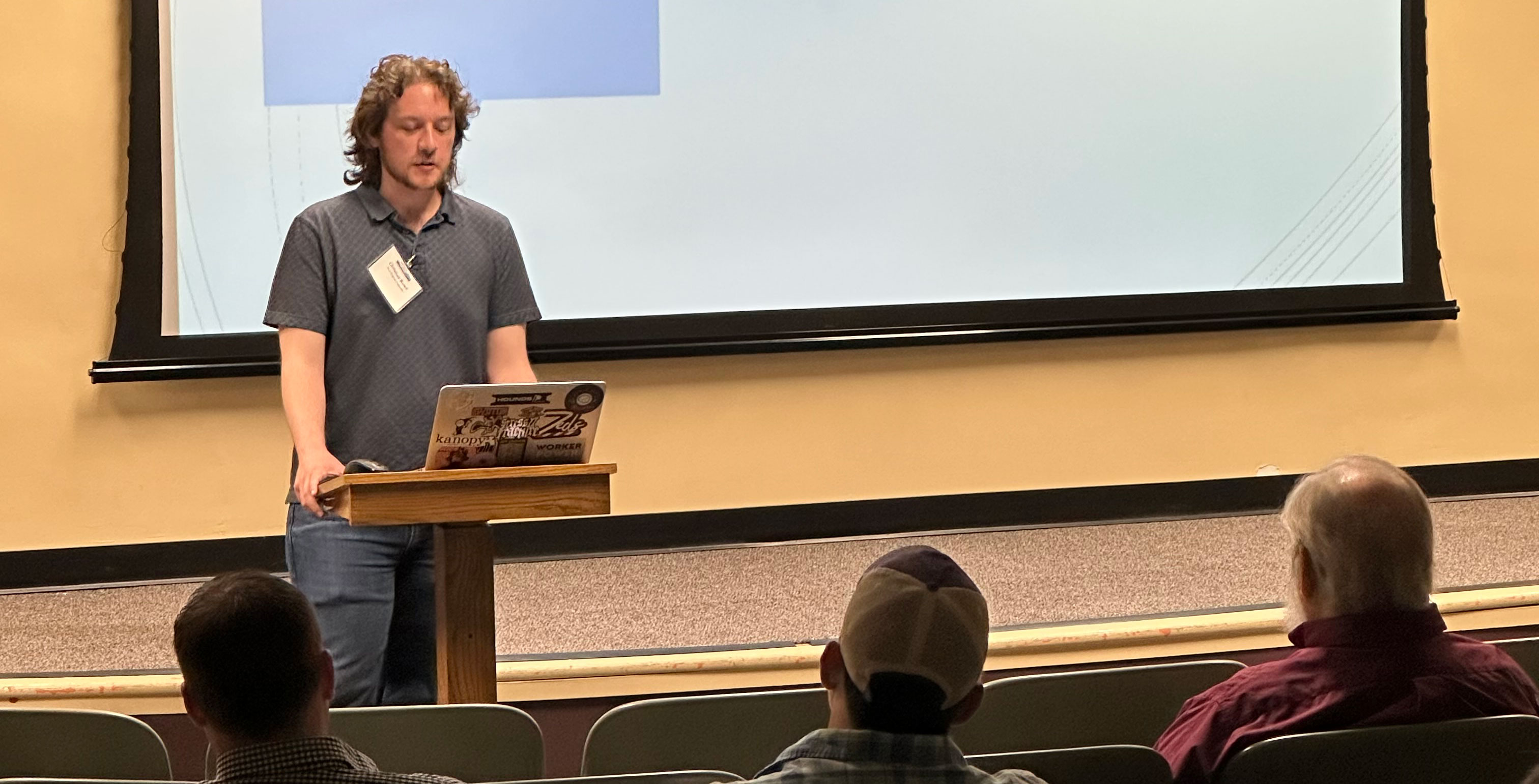 Presenter at podium in front of screen