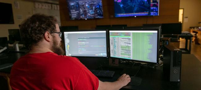 Student working with multiple computer monitors