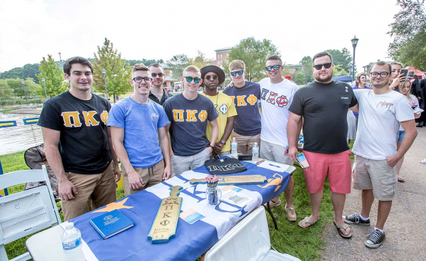 Group of fraternity brothers at booth