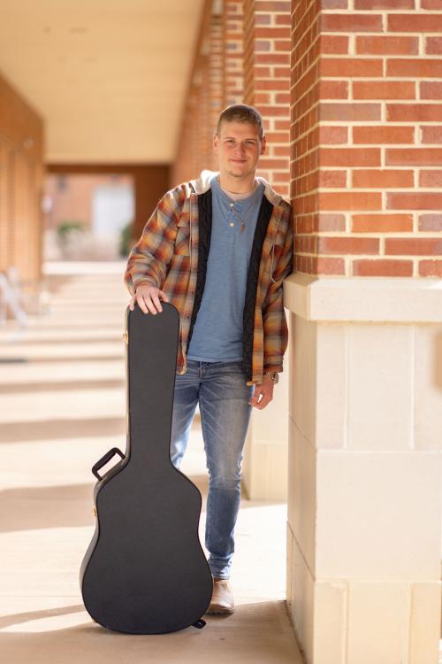 Aiden Bowman with guitar case