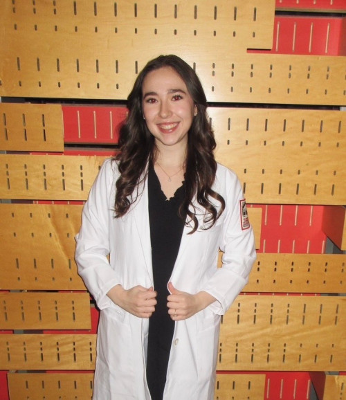 Nursing student posing for photo in white coat
