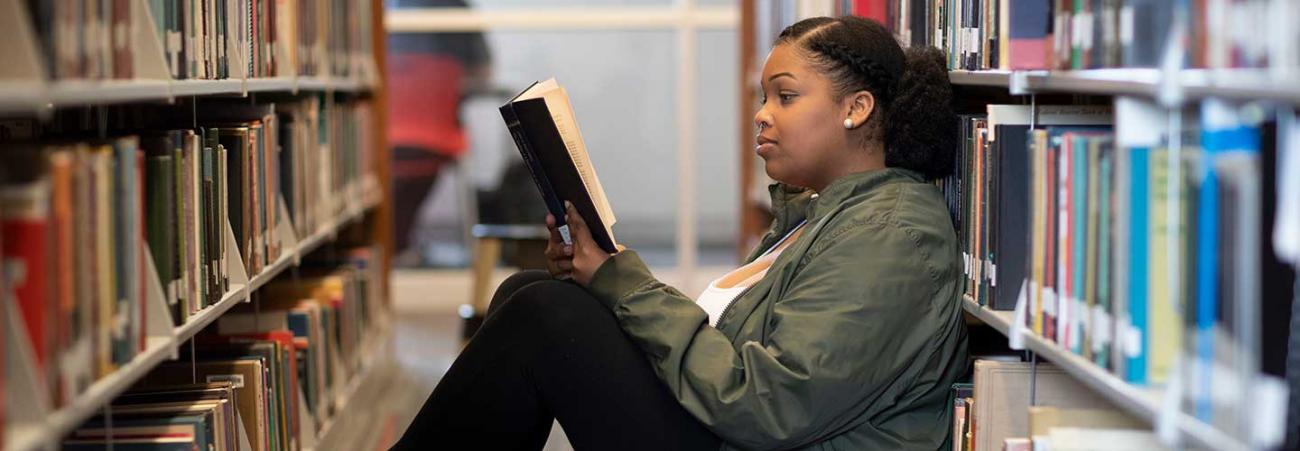 Student reading book in library