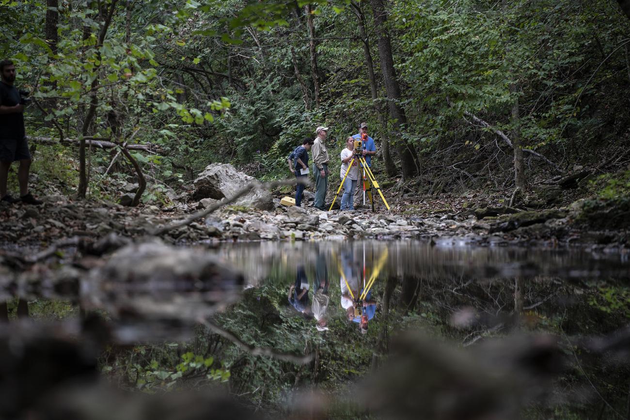 Students surveying by river