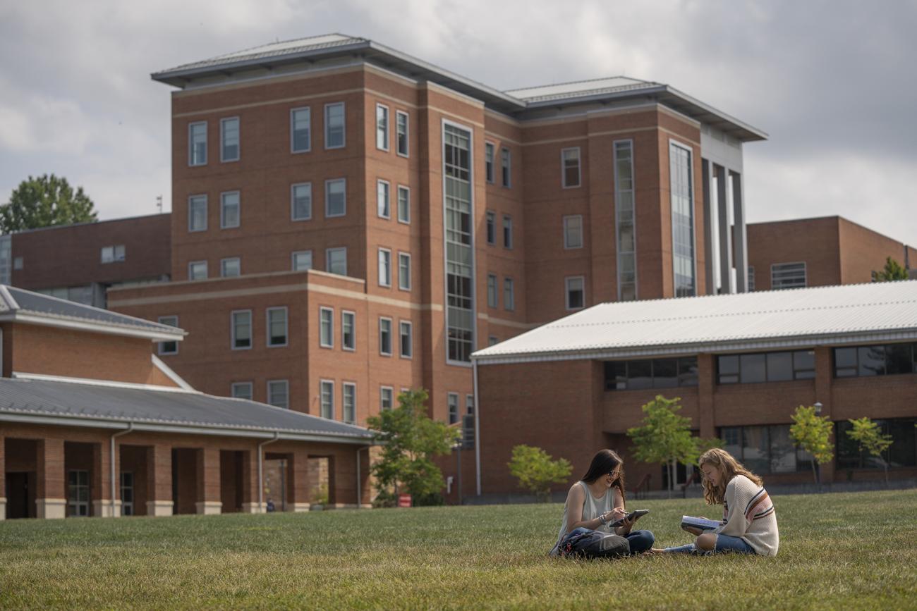 Students talking in the grass on campus