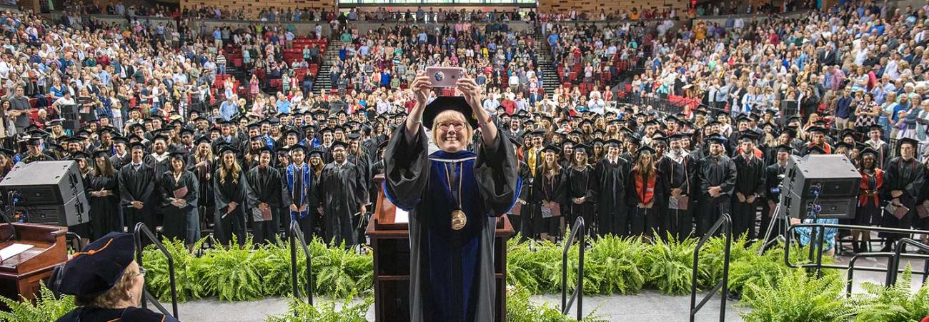 Chancellor Henry taking selfie on stage during Commencement