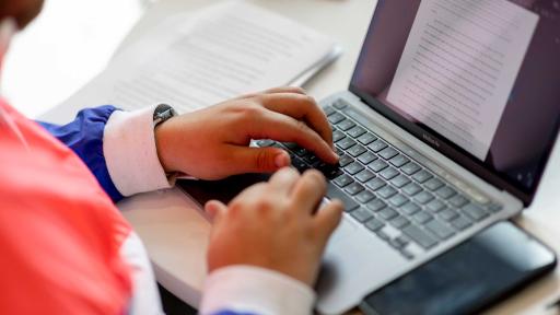 Hands typing on laptop