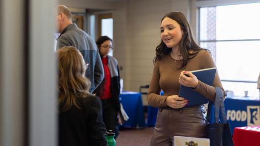 Lauren Montes speaking with employer at career fair