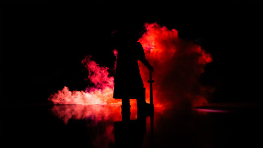 Smiddy stands in the smoke and shadows